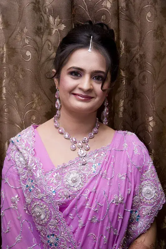 Bride in pink saree showcasing bridal makeup and jewelry